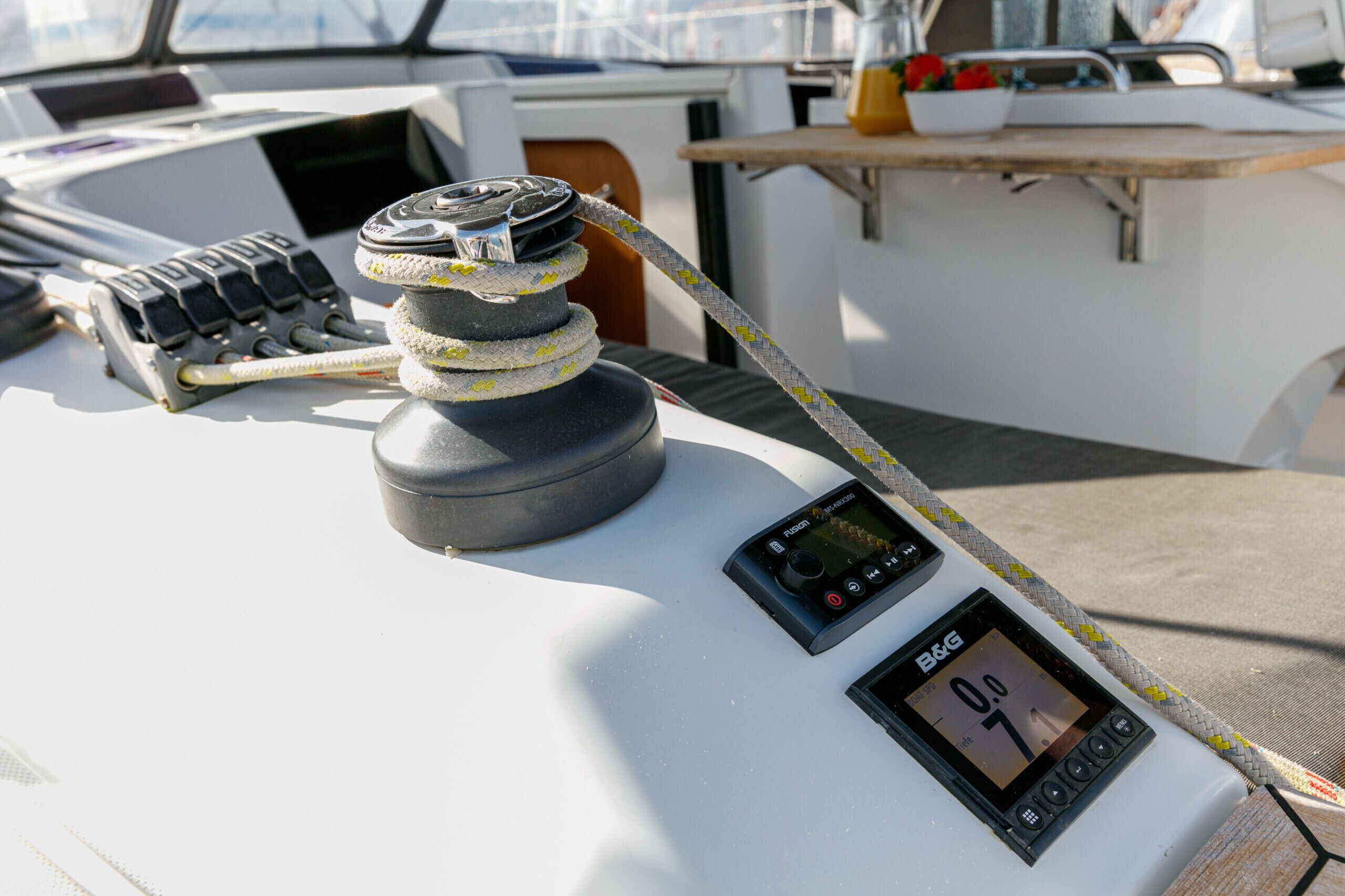 Un panneau de commande de bateau avec un treuil, un écran numérique et une corde.