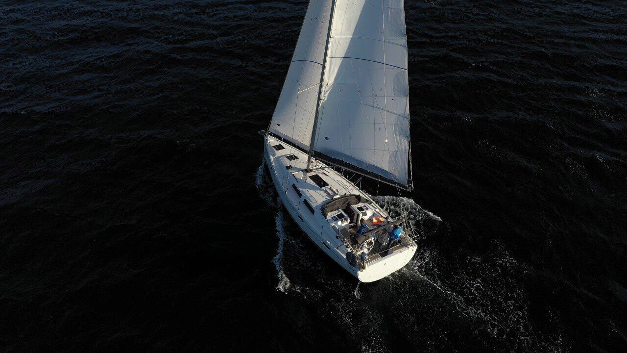 A sailboat with a single mast and a cabin, sailing on the water.