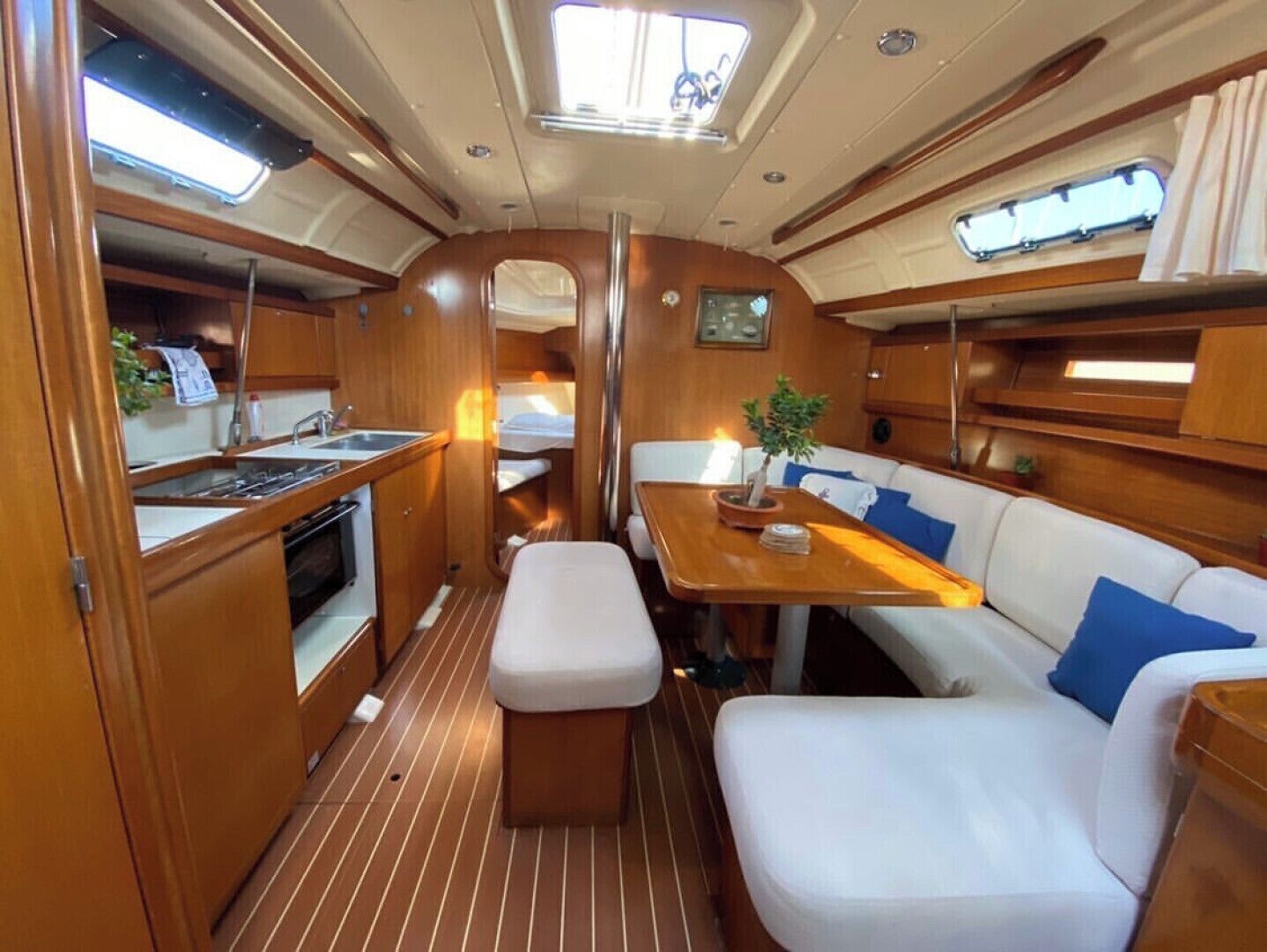 A compact galley with a sink, stove, and storage cabinets.