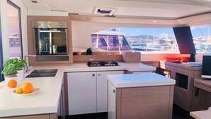 A modern kitchen with a built-in oven, a sink, and a small island with a countertop. - Sun-kissed Sailing Adventure in Split-Dalmatia, Croatia (Seget Donji)