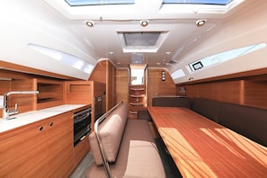 A compact kitchen with a central island, a dining area with a bench, and a small seating space. - Sun-Kissed Sailing Adventure in Zadar, Croatia (Biograd na moru)