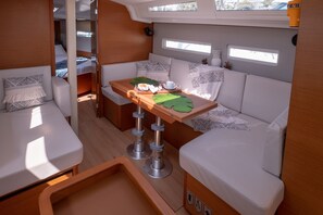 A compact, well-lit interior with a dining area, seating, and a small kitchenette. - Sun-Kissed Sailing Adventure in the Ionian Islands, Lefkada (Lefkada)