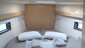 A compact, well-lit cabin with a single bed, wooden headboard, and two small windows. - Sun-Kissed Sailing Adventure in the Ionian Islands, Lefkada (Lefkada)
