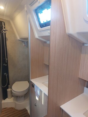 A compact bathroom with a shower, toilet, and a small window. - Sun-Kissed Sailing Adventure in the Ionian Islands, Lefkada (Lefkada)