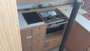 A compact kitchen with a stove, sink, and storage cabinets. - Sun-Kissed Sailing Adventure in the Ionian Islands, Lefkada (Lefkada)
