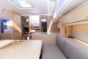 A compact RV interior with a kitchenette, a dining area, and a seating space. - Sun-kissed Sailing Adventure in Split-Dalmatia, Croatia (Trogir)