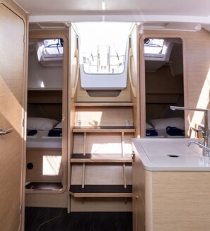 A compact RV interior with two beds, a sink, and a small window. - Sun-kissed Sailing Adventure in Split-Dalmatia, Croatia (Trogir)