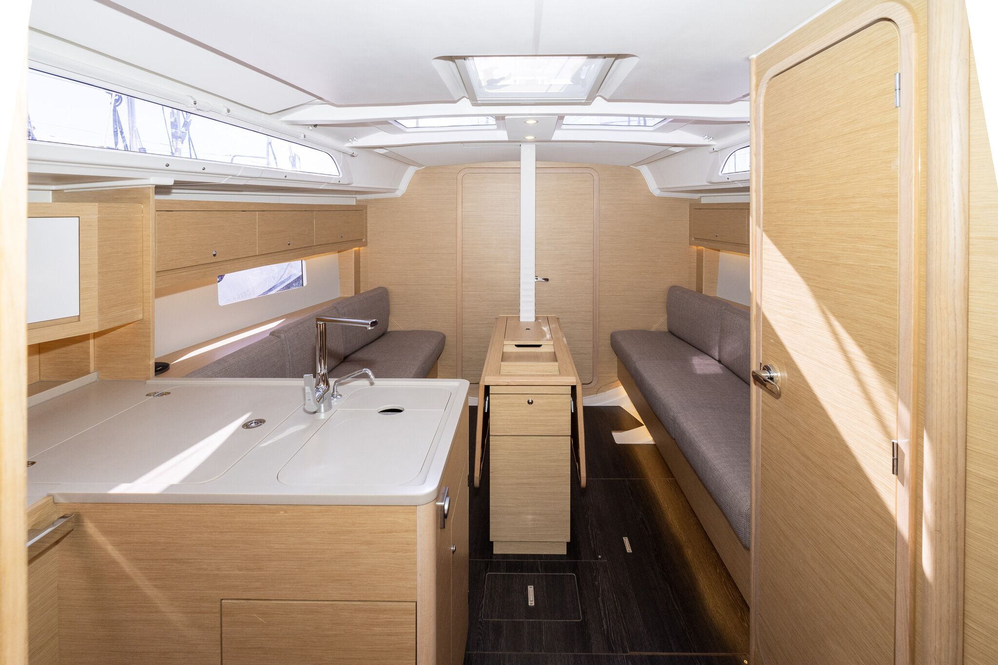 Un intérieur de camping-car compact comprenant un coin cuisine, un espace salon et une cloison centrale.