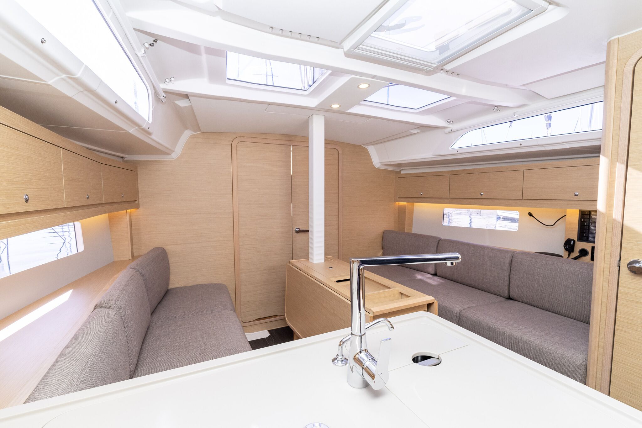 A compact, well-lit interior with a sofa, a small table, and a window.