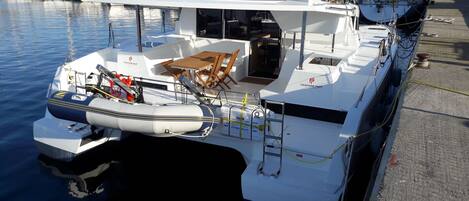 A boat with a dining area, a motor, and a cabin.