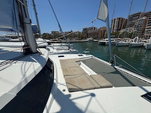 A marina with boats docked, a clear sky, and buildings in the background. - Sun-Kissed Sailing Adventure in Islas Baleares, Mallorca (Palma)