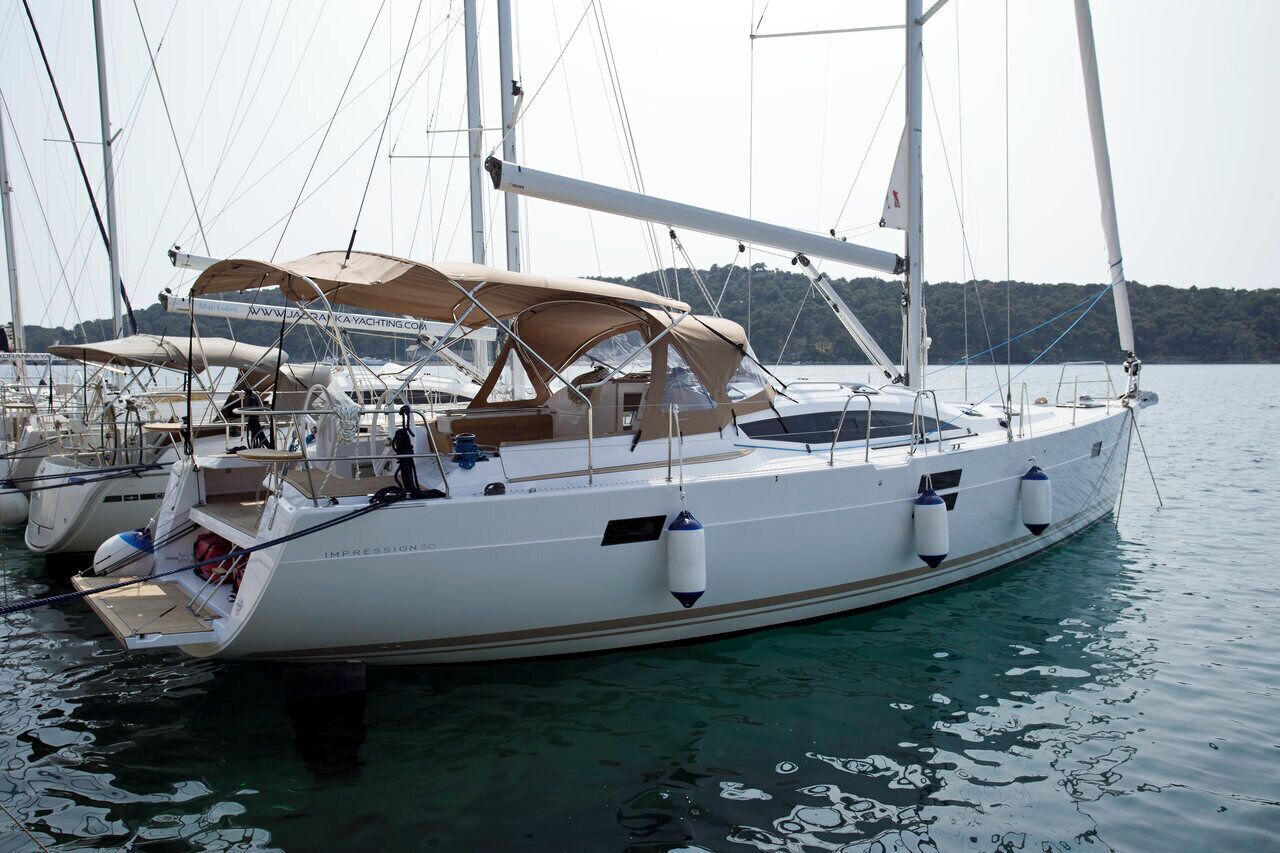 A white yacht with a covered deck, a cabin, and a visible website address on the side.