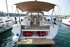 A boat with a covered deck, seating area, and storage compartments. - Sun-Kissed Sailing Adventure in Istria, Croatia (Pula)