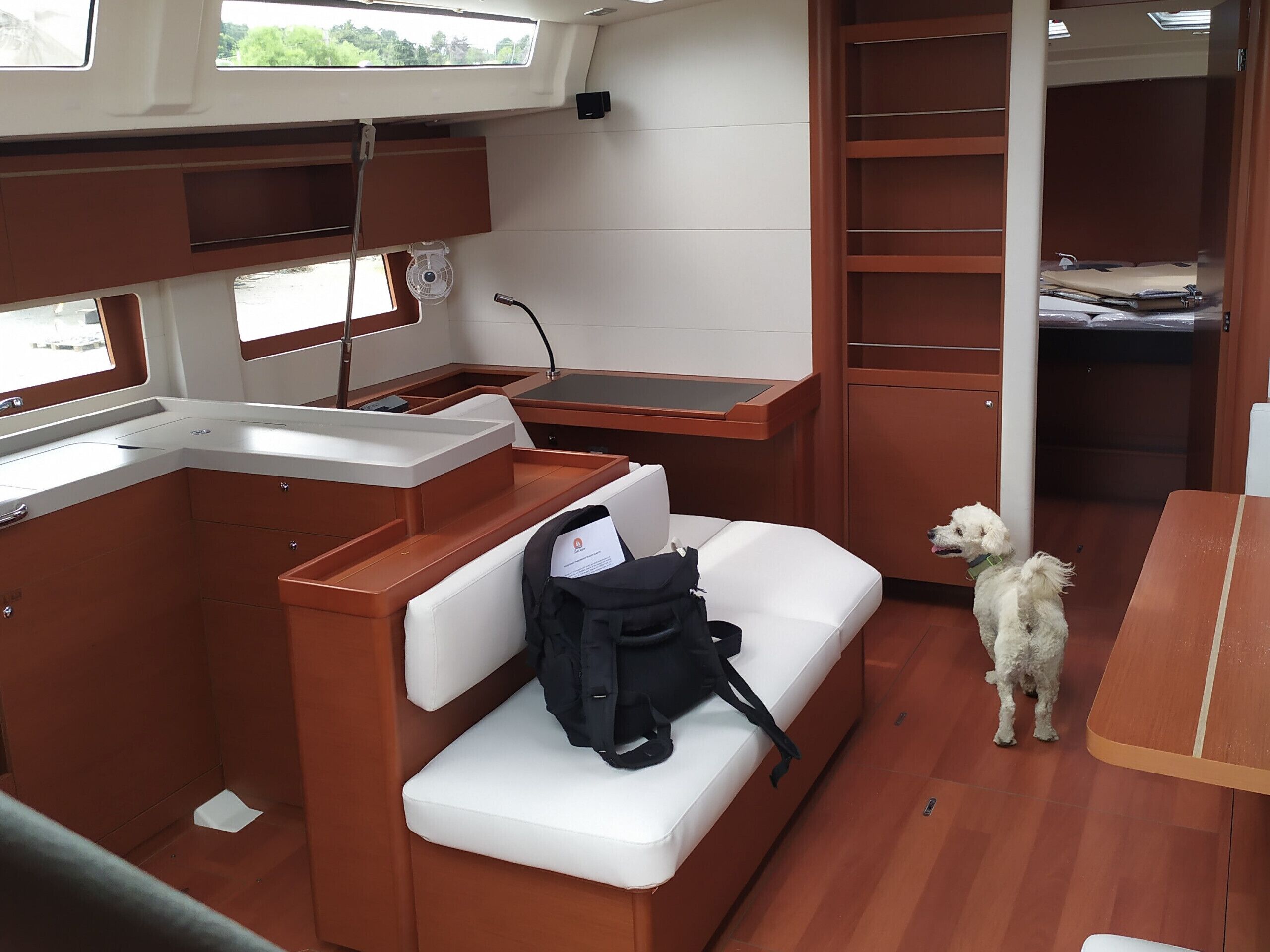 A compact kitchenette with a sink, a fan, and a small table.