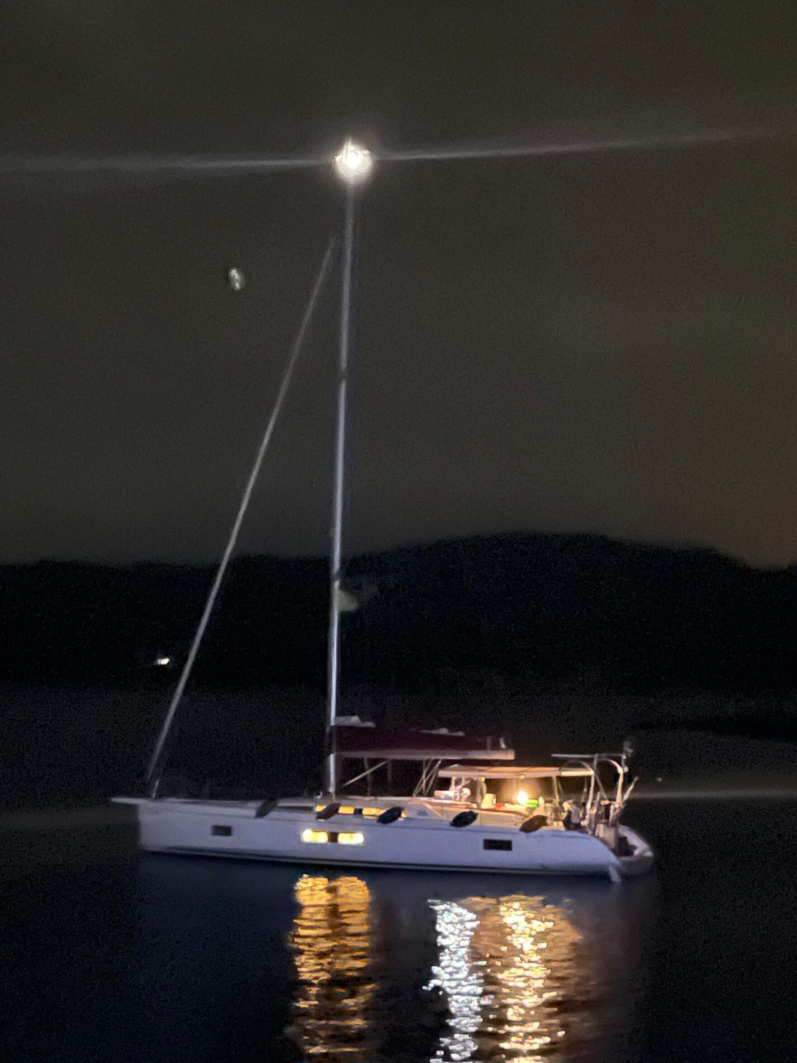 Un bote con una luz en la parte superior, una cabina y un reflejo en el agua.