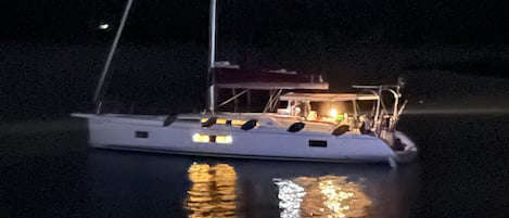 Un bote con una luz en la parte superior, una cabina y un reflejo en el agua.