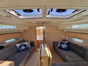 A compact interior with two sofas, a central table, and skylights. - Sun-Kissed Sailing Adventure in Istria, Croatia (Pula)