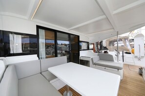 A modern yacht interior with a dining area, seating, and a view of the sea. - Sibenik Sun-soaked Sailing: A Luxurious Croatian Voyage (Pirovac)