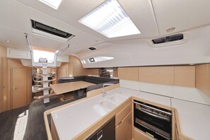A compact kitchen with a sink, stove, and storage cabinets. - Sun-Kissed Sailing Adventure in Zadar, Croatia (Biograd na moru)