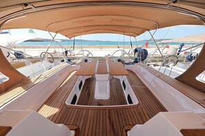 A boat deck with a central table, steering wheel, and various equipment. - Sun-Kissed Sailing Adventure in Zadar, Croatia (Biograd na moru)