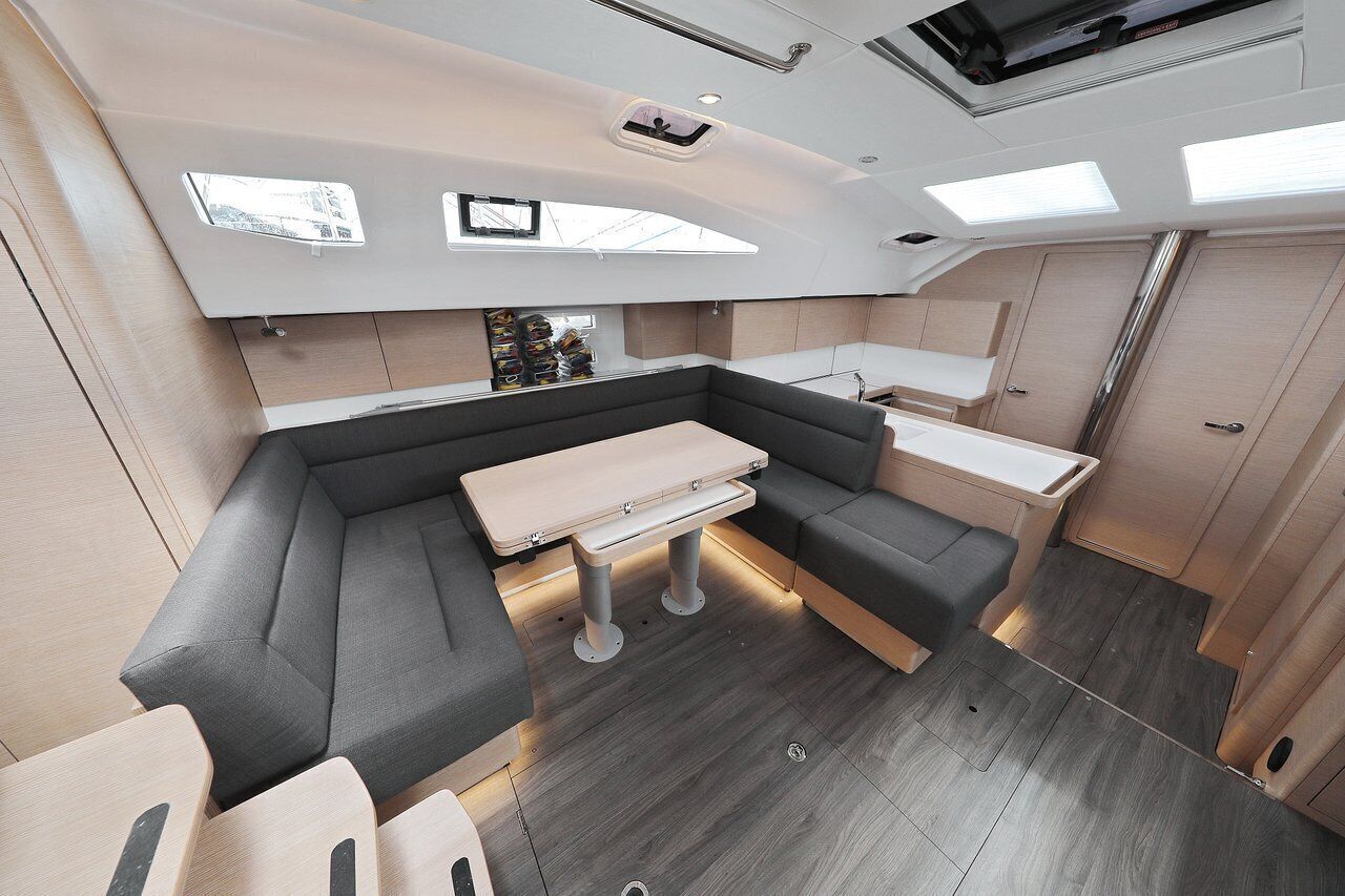 A compact interior with a sofa, a small table, and a kitchenette area.