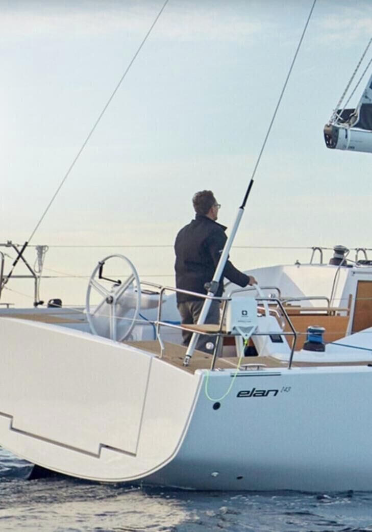 A person standing on a boat with a steering wheel and a control panel.