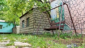 Un bâtiment en pierre avec une fenêtre, une balançoire et une fresque murale.
