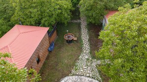 Une cour intérieure avec un bâtiment en briques, un chemin de pierre et une végétation luxuriante.