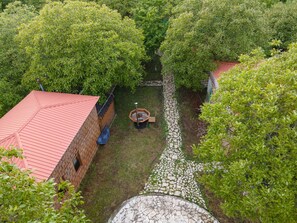 A courtyard with a brick building, a stone pathway, and lush greenery.
