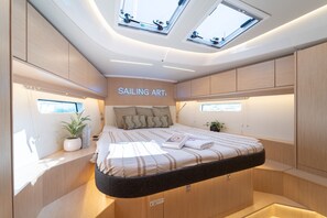 A compact, modern bedroom with skylights, a bed with a striped bedspread, and a 'SAILING ART' sign. - Sibenik Sun-soaked Sailing: A Luxurious Croatian Voyage (Pirovac)