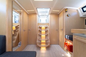 A narrow corridor with wooden cabinets and a central shelf unit. - Sibenik Sun-soaked Sailing: A Luxurious Croatian Voyage (Pirovac)