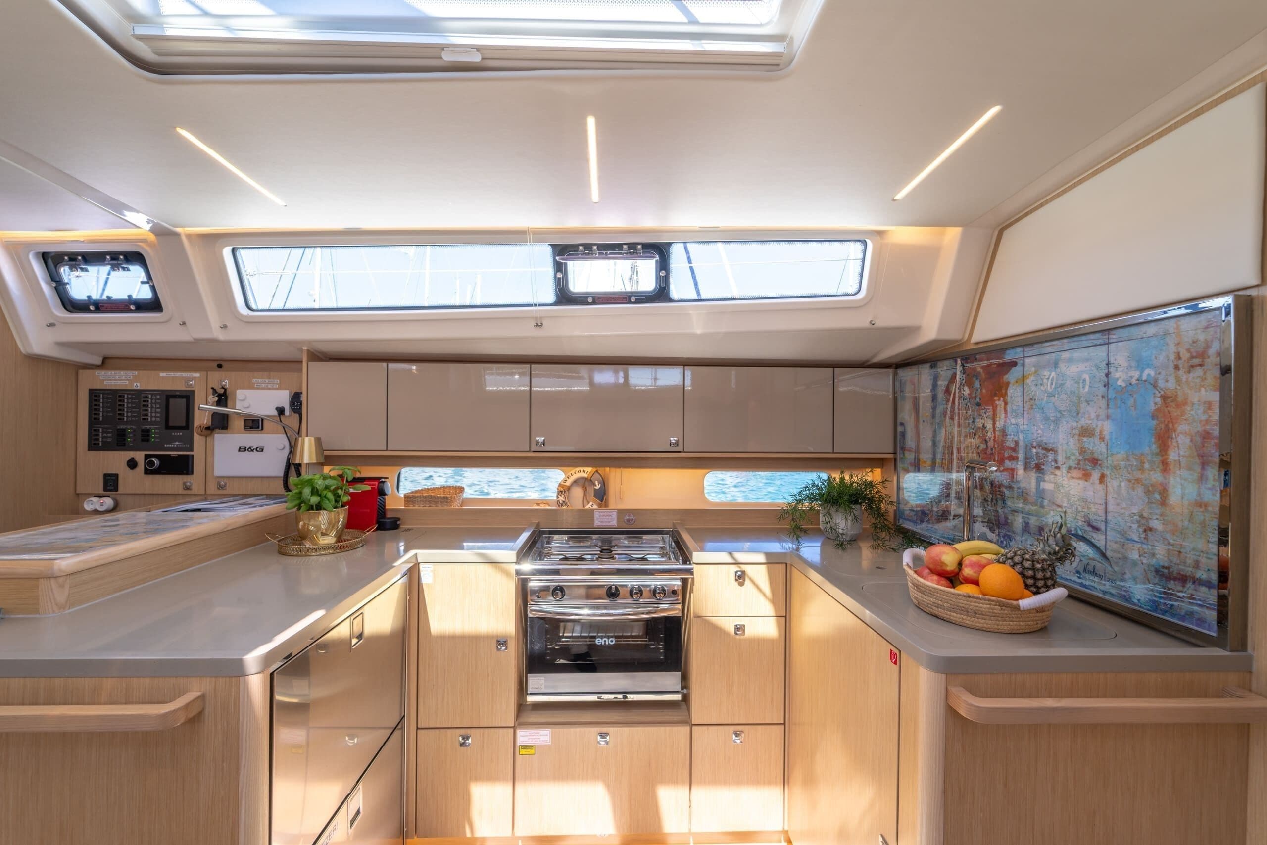 Una cocina moderna con estufa, horno y un frutero en la encimera.