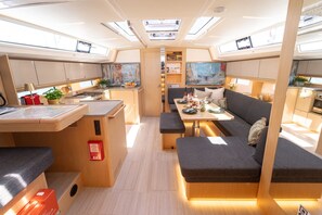 A compact, well-lit interior with a kitchenette, dining area, and seating. - Sibenik Sun-soaked Sailing: A Luxurious Croatian Voyage (Pirovac)