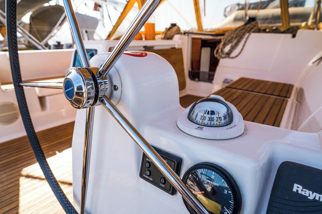 A boat's control panel with a compass, a speedometer, and a winch.