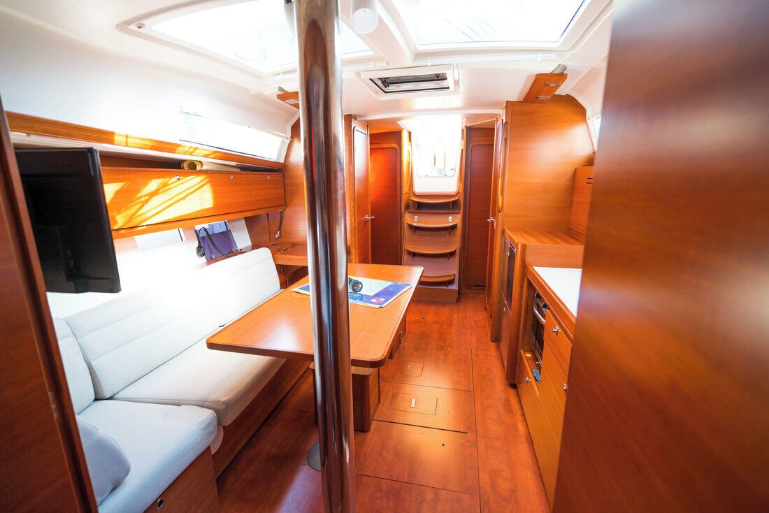 A compact interior with a sofa, a table, and a small kitchenette.