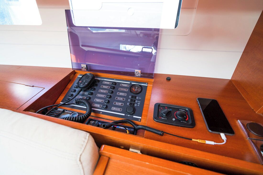 Una consola de madera con una radio, teléfono y cable de carga.