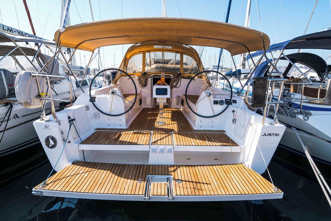 Ein Yachttdeck mit Holzboden, Steuer und Bedienfeld.