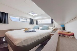 A modern, compact bedroom with a skylight, a bed, bedside tables, and a view of the sky. - Dubrovnik Delight: A Sun-Kissed Sailing Experience (Komolac)