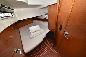 A compact cabin with a bed, a small window, and a door. - Sun-Kissed Sailing Adventure in Zadar, Croatia (Bibinje)
