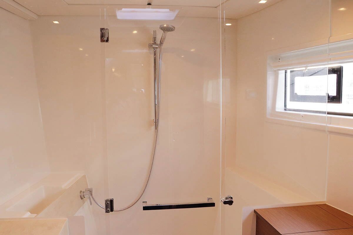Un baño moderno con cabina de ducha de vidrio, bañera y ventana que proporciona luz natural.