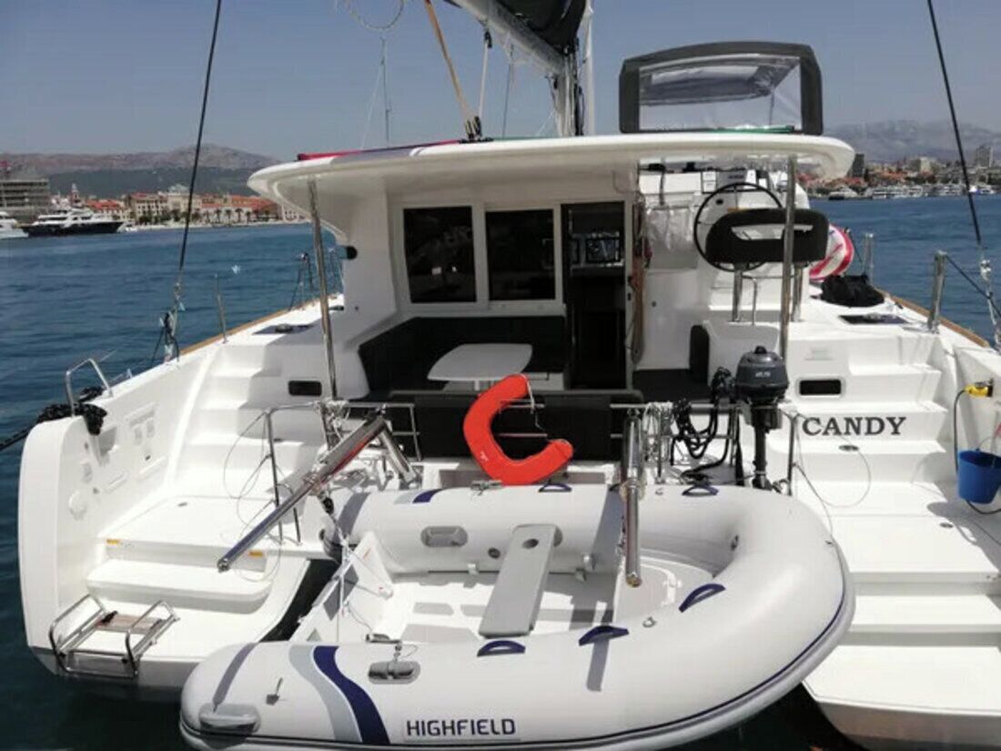 A boat with a white deck, a steering wheel, and a name 'CANDY' on the side.