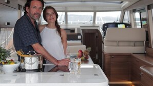 A couple dining at a table with a view of the sea, a kitchen area, and a seating area with a view. - Sun-Kissed Sailing Adventure in Istria, Croatia (Pula)