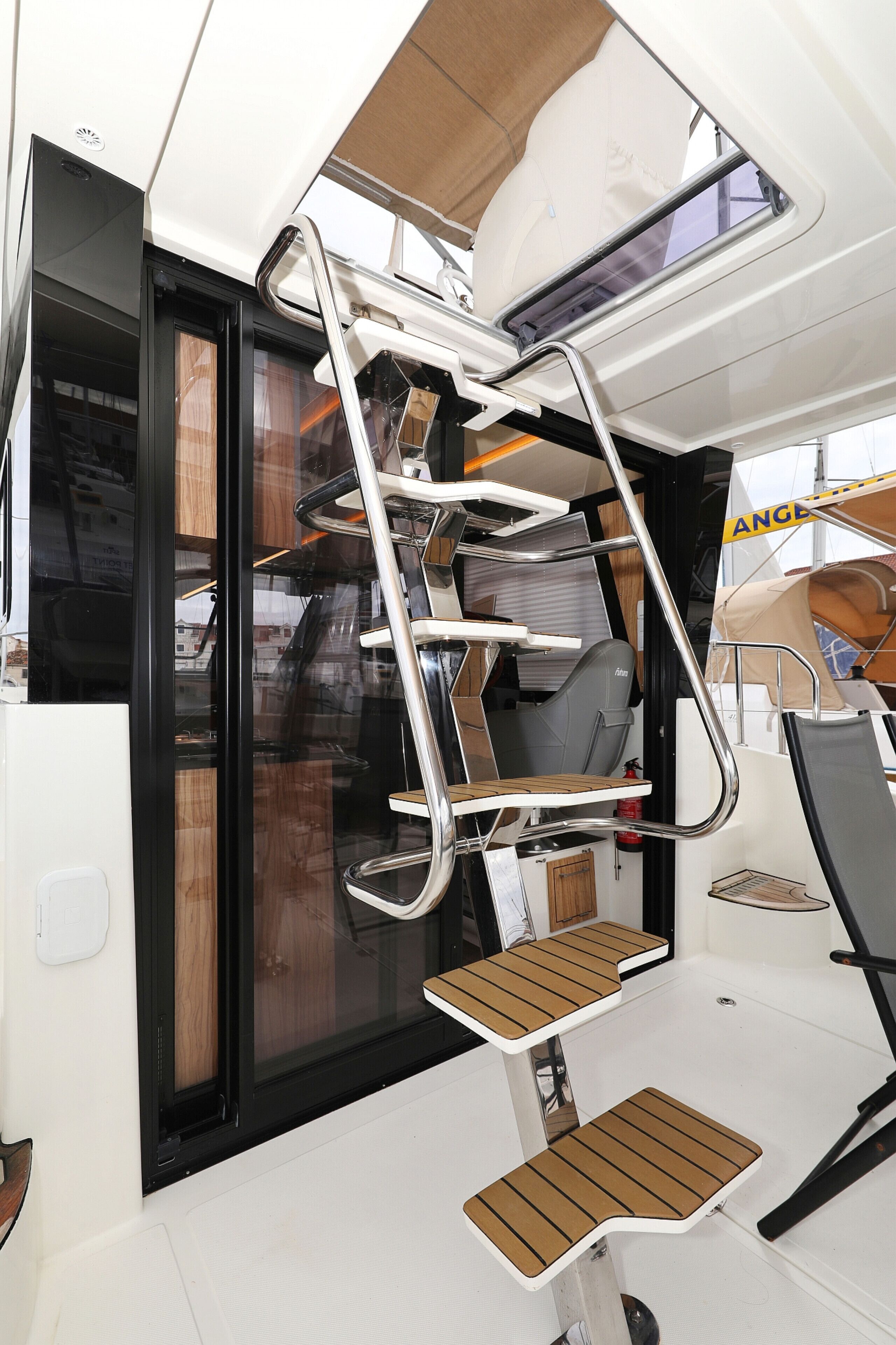 L'intérieur d'un bateau, avec une échelle en métal, une porte coulissante et une petite table.