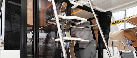 A boat interior with a metal ladder, a sliding door, and a small table.