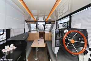 Ein modernes Interieur mit einem Holztisch, Sitzgelegenheiten und einem Lenkrad.