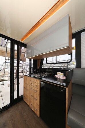 Una cocina compacta con estufa, horno y armarios de madera.