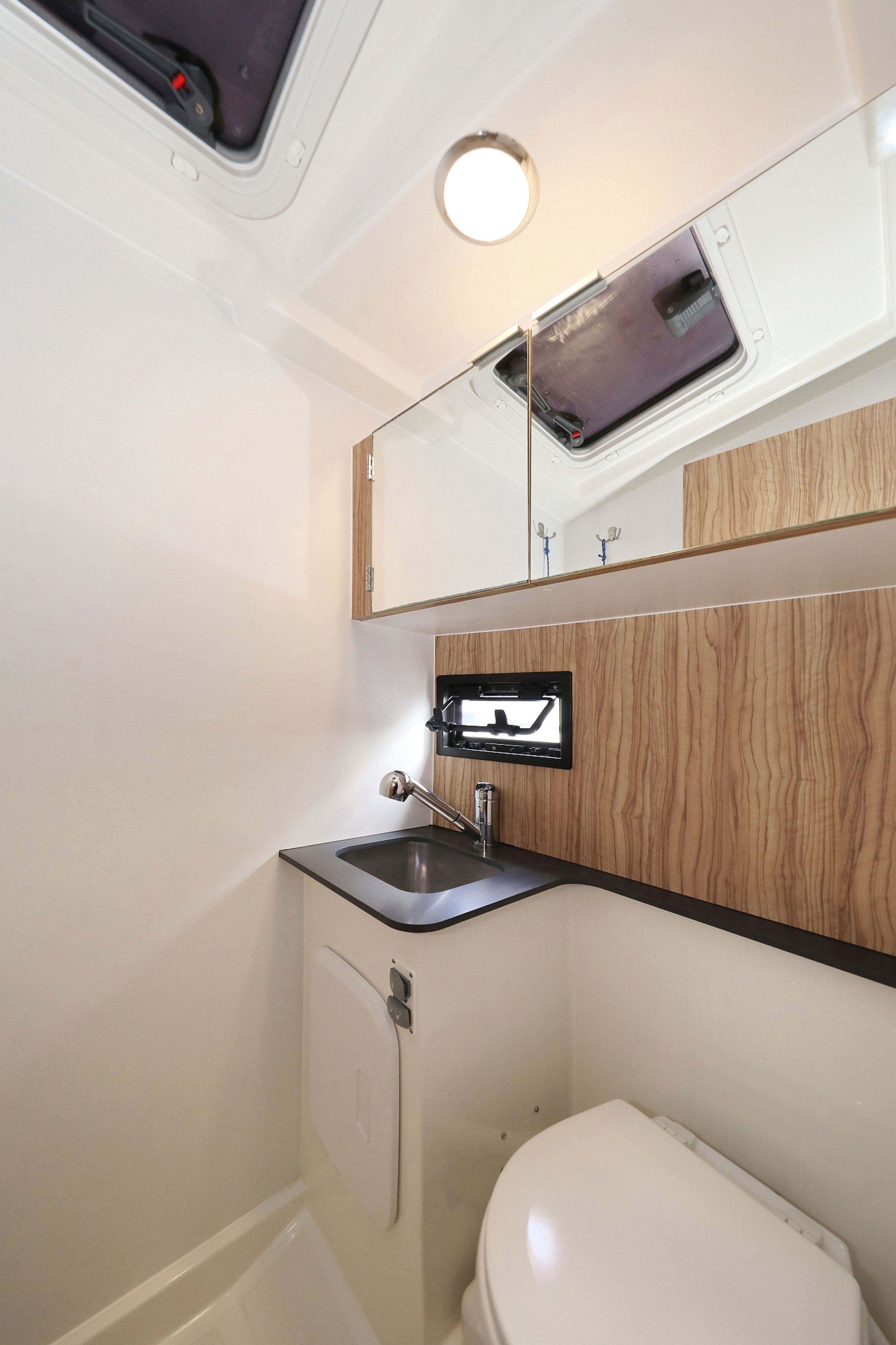 Un baño pequeño con inodoro, lavabo y espejo.