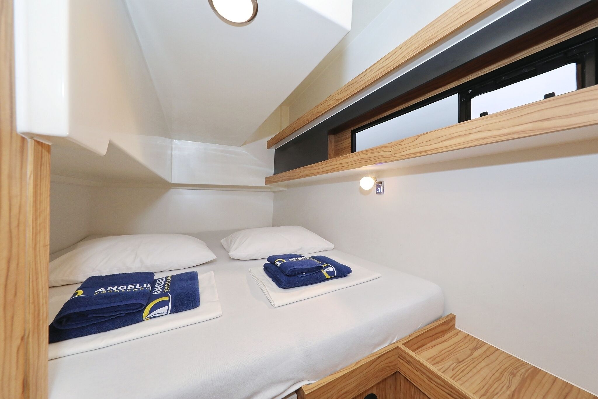 Una habitación pequeña con cama, ventana y un estante.