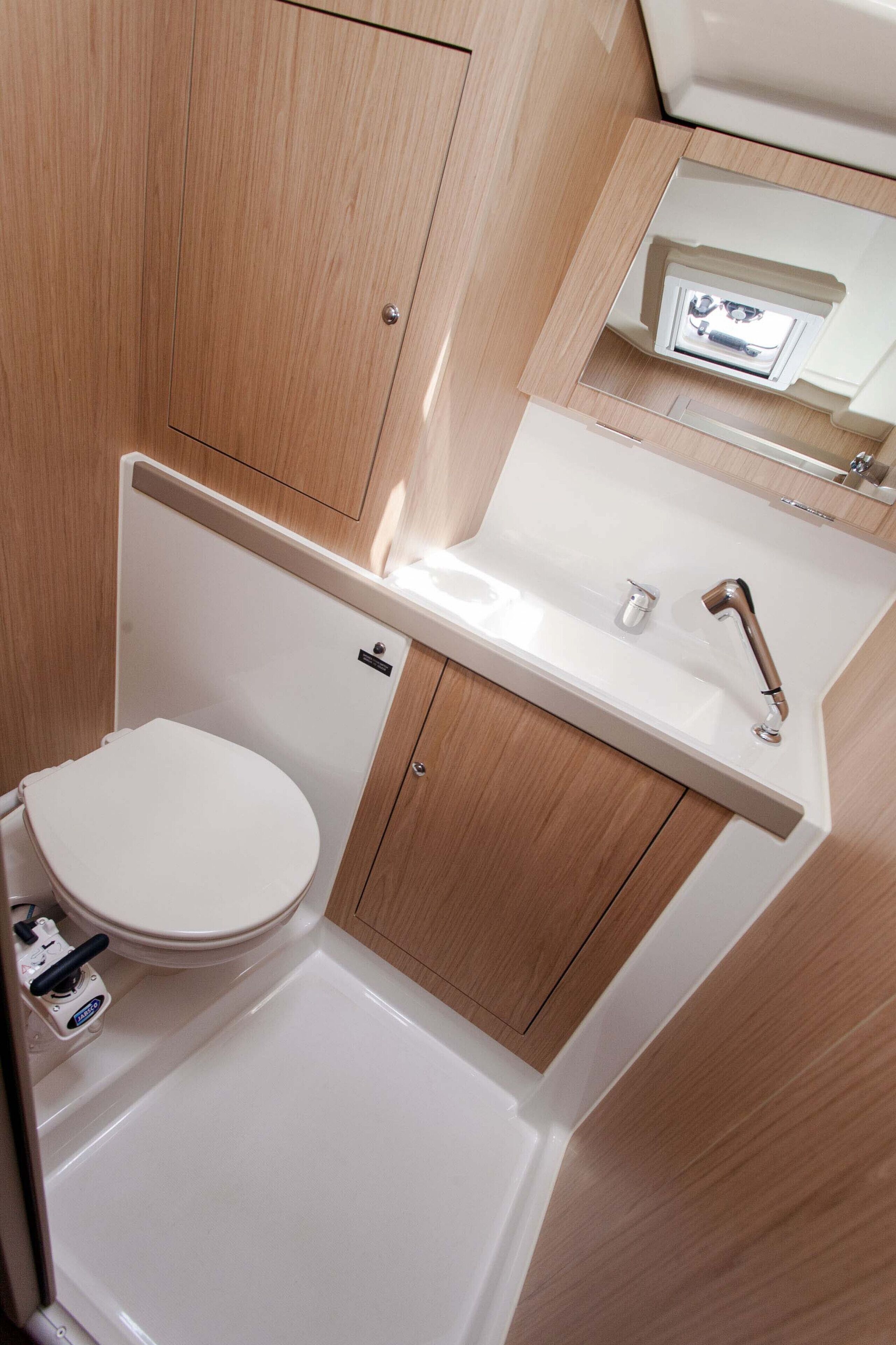 Une petite salle de bain comprenant des toilettes, un lavabo et un miroir.