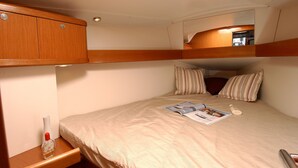 A bunk bed with a magazine, a bottle, and a pillow on the bed.